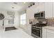 A modern kitchen features an island with a sink, stainless steel appliances and white cabinets at 5665 Piccolo St, Nokomis, FL 34275