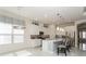 Open-concept kitchen featuring white cabinets, stainless appliances, a center island, and pendant lighting at 5665 Piccolo St, Nokomis, FL 34275