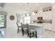 Modern kitchen with white cabinetry, stainless steel appliances, and a large center island with seating at 5665 Piccolo St, Nokomis, FL 34275