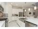 Bright kitchen features stainless steel appliances, island with sink, and crisp white cabinets and granite countertops at 5665 Piccolo St, Nokomis, FL 34275