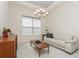 Bright living room featuring tray ceilings, decorative lighting, and a white leather sofa at 5665 Piccolo St, Nokomis, FL 34275