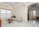 Bright living room featuring tray ceilings, decorative lighting, a white leather sofa and views of the foyer at 5665 Piccolo St, Nokomis, FL 34275