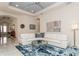 Comfortable living area with modern decor, a white leather sofa, and an elegant tray ceiling at 5665 Piccolo St, Nokomis, FL 34275