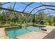 Outdoor pool area surrounded by lush greenery and screened enclosure at 5665 Piccolo St, Nokomis, FL 34275