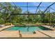 Sparkling in-ground pool surrounded by a screened enclosure and lush landscaping at 5665 Piccolo St, Nokomis, FL 34275