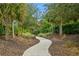 Scenic walking path winding through lush greenery and palm trees in the community at 5665 Piccolo St, Nokomis, FL 34275