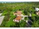 Aerial shot showing a large home with lush landscaping, a separate garage, and a circular driveway at 5694 Hale Rd, Venice, FL 34293