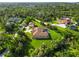 Expansive aerial view of a home with a large yard, mature trees, and a screened-in pool at 5694 Hale Rd, Venice, FL 34293