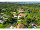 Wide aerial shot showing the home with circular driveway, bonus garage, and lush surrounding greenery at 5694 Hale Rd, Venice, FL 34293