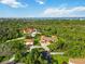 A birds eye view shows the home's landscape and surrounding trees with waterfront in the background at 5694 Hale Rd, Venice, FL 34293