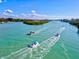 Picturesque aerial view of boats sailing through the waterfront, surrounded by lush greenery at 605 Cornwell On The Gulf, Venice, FL 34285