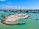 Scenic aerial view of a waterfront community and private beach with crystal turquoise water at 605 Cornwell On The Gulf, Venice, FL 34285