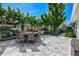 Lush backyard with a spacious patio, grill, and palm trees at 605 Cornwell On The Gulf, Venice, FL 34285