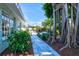 Landscaped backyard leads to patio with barbecue and dining area at 605 Cornwell On The Gulf, Venice, FL 34285
