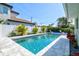 Backyard featuring a refreshing pool surrounded by tropical plants and lounge chairs for relaxing poolside at 605 Cornwell On The Gulf, Venice, FL 34285