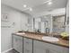 Elegant bathroom featuring dual sinks, granite countertops, and a large mirror at 605 Cornwell On The Gulf, Venice, FL 34285