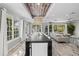 Elegant dining area featuring a long table, modern chandelier, and ample seating for large gatherings at 605 Cornwell On The Gulf, Venice, FL 34285