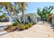 Beautifully landscaped home exterior with mature palm trees and lush plantings at 605 Cornwell On The Gulf, Venice, FL 34285