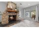 Charming stone fireplace with a decorative mantel and a view to the front yard at 605 Cornwell On The Gulf, Venice, FL 34285