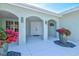 Covered front porch featuring double doors, stylish lighting, and decorative plants at 605 Cornwell On The Gulf, Venice, FL 34285