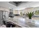 Modern kitchen with stainless steel appliances, a large island, and stylish countertops at 605 Cornwell On The Gulf, Venice, FL 34285