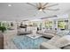 Expansive living area with a large sectional sofa, open floor plan, and abundant natural light at 605 Cornwell On The Gulf, Venice, FL 34285