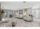 Spacious living room featuring stone fireplace, neutral furniture, and light wood-look floors at 605 Cornwell On The Gulf, Venice, FL 34285