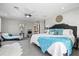 The spacious main bedroom features a chaise lounge, ceiling fan, and soft, neutral décor at 605 Cornwell On The Gulf, Venice, FL 34285