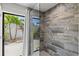 Large walk-in shower with stone tile and glass enclosure with exterior views at 605 Cornwell On The Gulf, Venice, FL 34285