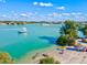 Picturesque waterfront view with boats, kayaks, and vibrant turquoise water on a sunny day at 605 Cornwell On The Gulf, Venice, FL 34285