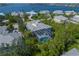 Stunning aerial view of waterfront home with screened pool, lush tropical landscaping, and tranquil blue waters at 746 Eagle Point Dr, Venice, FL 34285