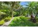 Lush green backyard features tropical palms and landscaping offering privacy and serene outdoor living at 746 Eagle Point Dr, Venice, FL 34285