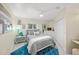 Serene bedroom featuring a queen-size bed, soft gray tones, and a bright blue accent rug at 746 Eagle Point Dr, Venice, FL 34285