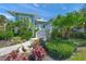 Beautiful coastal home with lush landscaping, a grand staircase, and a calming blue facade at 746 Eagle Point Dr, Venice, FL 34285