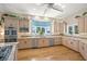 Well-lit kitchen featuring stainless steel appliances, abundant cabinets, and hardwood floors at 746 Eagle Point Dr, Venice, FL 34285