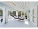 Cozy screened porch with a hanging swing bed, seating, and views of lush greenery at 746 Eagle Point Dr, Venice, FL 34285