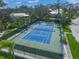 Aerial view of the community tennis court, surrounded by trees and lush landscaping for a recreational lifestyle at 746 Eagle Point Dr, Venice, FL 34285