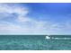 Calm Gulf waters under a clear blue sky, with a small motorboat speeding across the horizon at 746 Eagle Point Dr, Venice, FL 34285