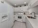 Well-lit kitchen featuring white cabinetry, modern appliances, and stone countertops at 748 White Pine Tree Rd # 208, Venice, FL 34285