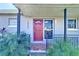 Charming home entrance with a vibrant red door, patterned tile, and inviting curb appeal at 7903 Hyde Park Ave, North Port, FL 34287