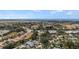 Expansive aerial view showing a neighborhood with tree-lined streets, the ocean, and a distant airport at 888 Guild Dr, Venice, FL 34285