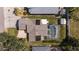 Aerial view of a home with a screened-in pool, solar panels, and mature trees at 888 Guild Dr, Venice, FL 34285