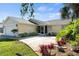 Charming single-story home with a well-manicured lawn, mature trees, and attached two-car garage at 888 Guild Dr, Venice, FL 34285
