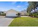 Charming single-story home with a well-manicured lawn, mature trees and attached two-car garage at 888 Guild Dr, Venice, FL 34285