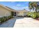 Well-maintained home with tropical landscaping, a paved driveway, and inviting front porch entrance at 888 Guild Dr, Venice, FL 34285