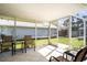 Enclosed lanai featuring tiled floors, comfortable seating, and views of the backyard at 888 Guild Dr, Venice, FL 34285