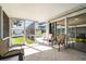Enclosed lanai featuring tiled floors, comfortable seating, and views of the pool and backyard at 888 Guild Dr, Venice, FL 34285