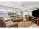 Light filled Florida room features sliding glass doors to pool area and a large flat screen television at 888 Guild Dr, Venice, FL 34285