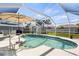 Screened-in pool with clear water, surrounded by a patio, seating, and lush landscaping at 888 Guild Dr, Venice, FL 34285
