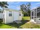 Outdoor shed with double windows and ramped entrance, surrounded by lush green grass and vibrant foliage at 888 Guild Dr, Venice, FL 34285